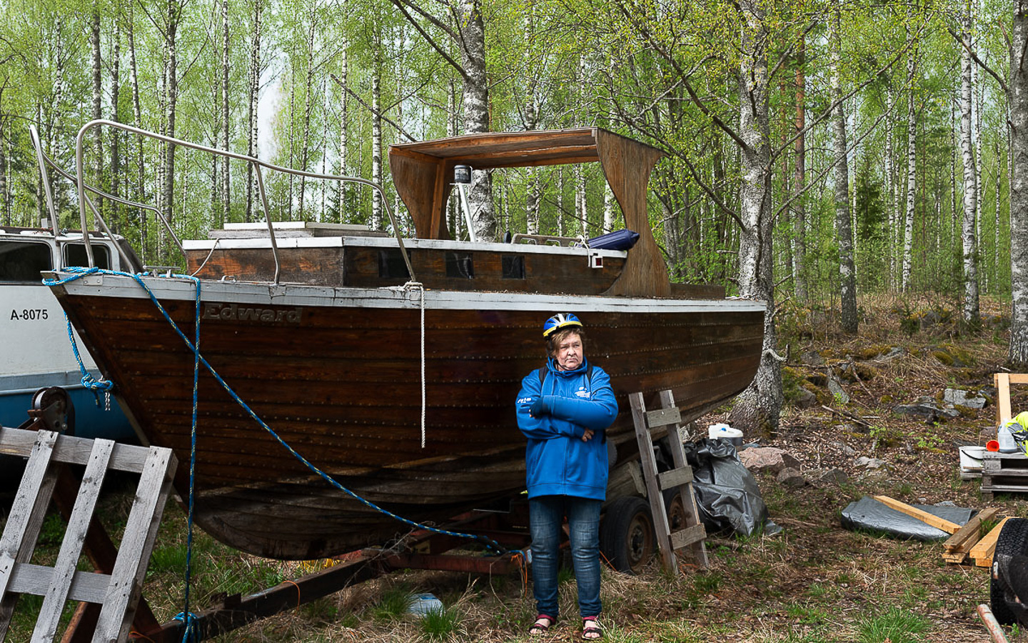 Kuvassa suuri puuvene omistajansa kanssa.